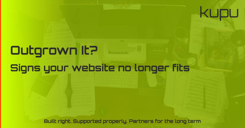 A cluttered desk with a spreadsheet and laptop, representing a business that has outgrown its website