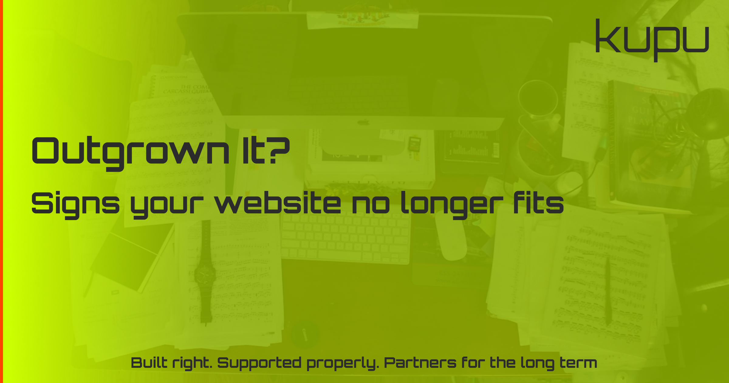 A cluttered desk with a spreadsheet and laptop, representing a business that has outgrown its website